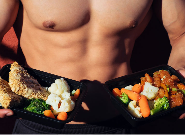 Fit man holding two plates of vegetables